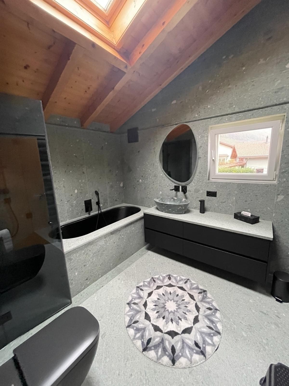 Salle d'eau en béton ciré et touches de noir au design industriel, réalisation DEN Sanitaire à Martigny